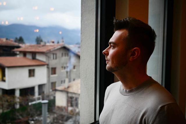 Oskar Train of Denmark looks from the window of a co-working centre in Bansko on February 13, 2026. Bulgaria's largest ski resort of Bansko in Pirin mountain is becoming a hub for digital nomads, copywriters, enterpreneurs and retirees from around the world. (Photo by Nikolay DOYCHINOV / AFP) / TO GO WITH AFP STORY BY ROSSEN BOSSEV