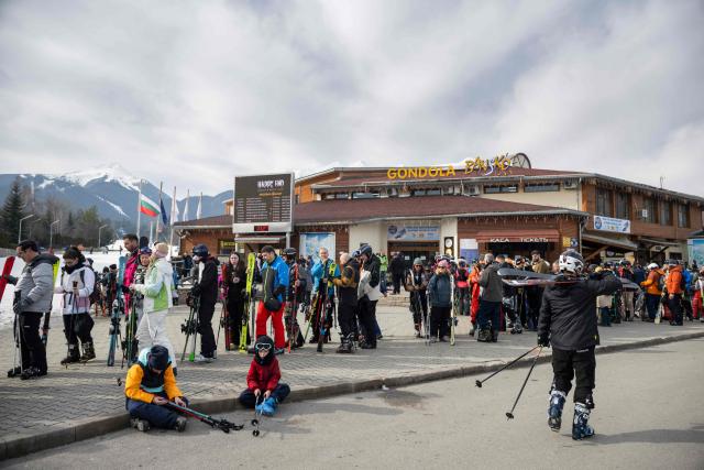 This photograph shows people waiting to get the gondola lift to the ski zone over Bansko on February 14, 2026. Bulgaria's largest ski resort of Bansko in Pirin mountain is becoming a hub for digital nomads, copywriters, enterpreneurs and retirees from around the world. According to recent data, almost one third of permanent residents in Bansko are foreigners. (Photo by Nikolay DOYCHINOV / AFP) / TO GO WITH AFP STORY BY ROSSEN BOSSEV