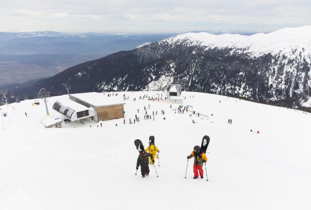 Snowboarders climb the Todorka peak in Pirin Mountains from the last station of the lift over Bansko on February 14, 2026. Bulgaria's largest ski resort of Bansko in Pirin mountain is becoming a hub for digital nomads, copywriters, enterpreneurs and retirees from around the world. (Photo by Nikolay DOYCHINOV / AFP) / TO GO WITH AFP STORY BY ROSSEN BOSSEV