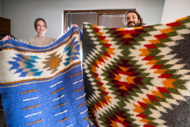 Svitlana Karabin, 37 and Viktor Vavrynchuk, 42, from Ukraine show hand-made rugs, that they sell in Bansko on February 15, 2026. Bulgaria's largest ski resort of Bansko in Pirin mountain is becoming a hub for digital nomads, copywriters, enterpreneurs and retirees from around the world. (Photo by Nikolay DOYCHINOV / AFP) / TO GO WITH AFP STORY BY ROSSEN BOSSEV