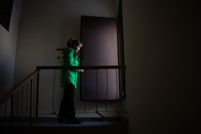 Local resident Tetyana Chernyshenko, 55, enters the rooftop of her residential building to inspect solar panels installed to mitigate the effects of power outages in Kyiv on February 19, 2026, amid the Russian invasion of Ukraine. As Ukraine accuses Russia of trying to freeze the population into submission with its most intense attacks on the energy network of the entire war, more and more people in Kyiv are fundraising and pooling cash to buy alternative sources of shared electricity. (Photo by HENRY NICHOLLS / AFP)