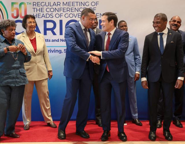 US Secretary of State Marco Rubio shakes hands with Jamaica's Prime Minister Andrew Holness during a family photo with Caribbean Community (CARICOM) heads of government in Basseterre, Saint Kitts and Nevis, February 25, 2026. Rubio is meeting with Caribbean leaders seeking a common line on Venezuela and pressure on Cuba. He's also addressing President Donald Trump's priorities, including combating illegal immigration, drug trafficking and regional security. (Photo by Jonathan Ernst / POOL / AFP)