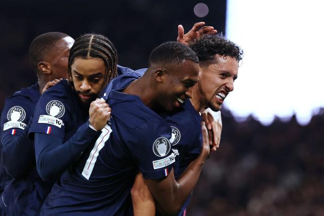 Paris Saint-Germain's French forward #29 Bradley Barcola (L), Paris Saint-Germain's Ecuadoran defender #51 Willian Pacho (C) congratulate Paris Saint-Germain's Brazilian defender #05 Marquinhos (R) after he scored Paris Saint-Germain's first goal during the UEFA Champions League play-off second leg football match between Paris Saint-Germain (PSG) and AS Monaco at the Parc des Princes stadium in Paris on February 25, 2026. (Photo by FRANCK FIFE / AFP)