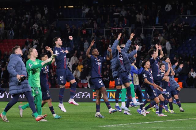 Paris Saint-Germain's players celebrate their victory at the end of the UEFA Champions League play-off second leg football match between Paris Saint-Germain (PSG) and AS Monaco at the Parc des Princes stadium in Paris on February 25, 2026. (Photo by Thomas SAMSON / AFP)