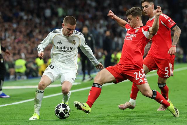 Real Madrid's Argentinian midfielder #30 Franco Mastuantono (L) vies for the ball with SL Benfica's Swedish defender #26 Samuel Dahl during the UEFA Champions League knockout round play-off second leg football match between Real Madrid CF and SL Benfica at Santiago Bernabeu Stadium in Madrid on February 25, 2026. (Photo by Pierre-Philippe MARCOU / AFP)