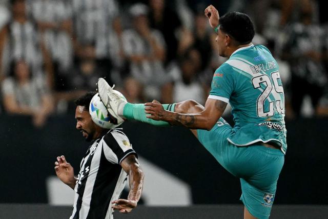 TOPSHOT - Nacional Potosi's defender #25 Juan Orellana (R) fouls Botafogo's defender #02 Vitinho (L) during the Copa Libertadores phase two second-leg football match between Brazil's Botafogo and Bolivia's Nacional Potosi at the Nilton Santos Stadium in Rio de Janeiro, Brazil, on February 25, 2026. (Photo by Mauro PIMENTEL / AFP)