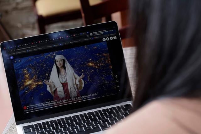 Albanian actress Anila Bisha looks at a screen during an AFP interview in Tirana on February 19, 2026 following the creation of AI-generated chatbot named "Diella", using her likeness and voice, delivered a speech in parliament without her knowledge. Over a 30-year career, Albanian actor Anila Bisha became renowned for playing complex women on the stage and screen, but now she lives in the shadow of her 'AI-generated' clone and a performance she never gave. Last September, Albania's Prime Minister Edi Rama announced, with much fanfare, the appointment of what he claimed was the first AI-generated minister, tasked with preventing corruption in public tenders. Within days, 'the minister' would deliver its inaugural parliamentary speech. (Photo by Adnan Beci / AFP)