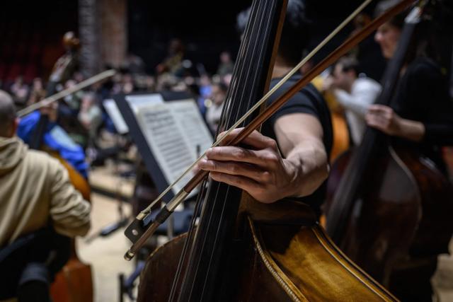 A musician prepares as psychiatric patients suffering from depression, bipolar disorder, schizophrenia, or personality disorders attend rehearsals of the Toulouse orchestra as part of the 'Résonance(s)' project to promote their recovery, at the Halle aux Grains theatre in Toulouse Southwestern France on February 10, 2026. The project was launched in 2023 through a partnership between the renowned Orchestre National du Capitole and several mental health institutions in the region. Its aim, in the face of conditions that can trap patients in a negative self-image, is to allow them to attend four rehearsals a year to initiate a process of reconnecting with others and the outside world, and simply to promote their recovery. (Photo by Ed JONES / AFP) / TO GO WITH AFP STORY BY Valentin GRAFF