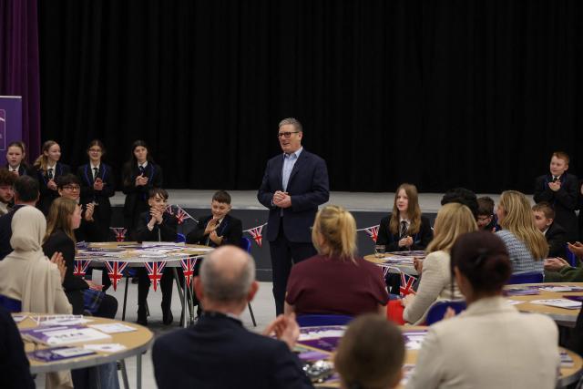 Britain's Prime Minister Keir Starmer (C) speaks with students and staff during a visit to the Walbottle Academy Campus in suburban Newcastle-upon-Tyne, north-east England on February 26, 2026, as part of his fight to reduce the high cost of living and highlight the government’s plan to raise standards for schools. (Photo by SCOTT HEPPELL / POOL / AFP)