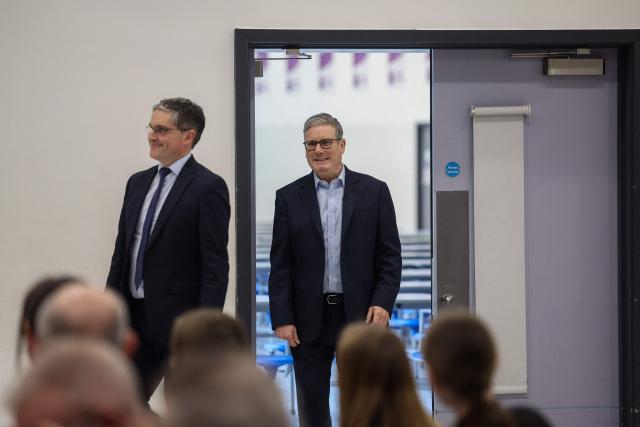 Britain's Prime Minister Keir Starmer (R) arrives for a visit to the Walbottle Academy Campus in suburban Newcastle-upon-Tyne, north-east England on February 26, 2026, as part of his fight to reduce the high cost of living and highlight the government’s plan to raise standards for schools. (Photo by SCOTT HEPPELL / POOL / AFP)