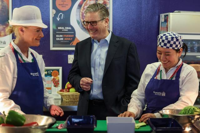 Britain's Prime Minister Keir Starmer (C) meets with catering staff during a visit to the Walbottle Academy Campus in suburban Newcastle-upon-Tyne, north-east England on February 26, 2026, as part of his fight to reduce the high cost of living and highlight the government’s plan to raise standards for schools. (Photo by SCOTT HEPPELL / POOL / AFP)