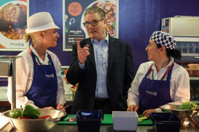 Britain's Prime Minister Keir Starmer (C) meets with catering staff during a visit to the Walbottle Academy Campus in suburban Newcastle-upon-Tyne, north-east England on February 26, 2026, as part of his fight to reduce the high cost of living and highlight the government’s plan to raise standards for schools. (Photo by SCOTT HEPPELL / POOL / AFP)