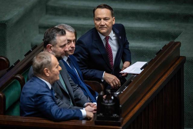 (L-R) Poland's Prime Minister Donald Tusk, Poland's Deputy Prime Minister and Minister of Defence Wladyslaw Kosiniak-Kamysz, Poland's Deputy Prime Minister and Minister of Digital Affairs Krzysztof Gawkowski and Poland's Deputy Prime Minister and Minister of Foreign Affairs Radoslaw Sikorski attend a session of the parliament, where the Minister of Foreign Afairs presented the main points of the Polish government's foreign policy, in Warsaw on February 26, 2026. (Photo by Wojtek RADWANSKI / AFP)