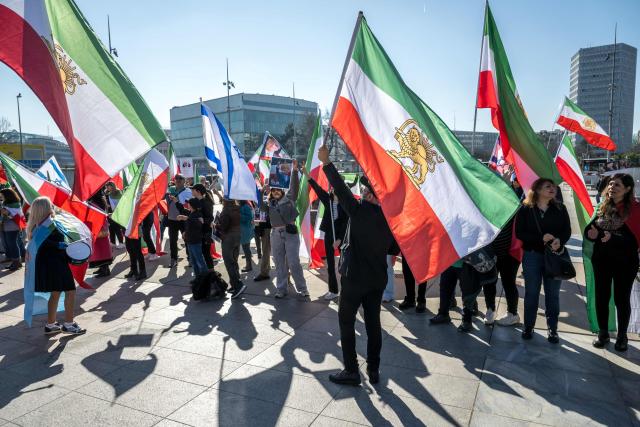 Protestors react and hold portraits of Reza Pahlavi II during a demonstration organised by members of the Iranian diaspora outside the United Nations offices during new round of talks between the United States and Iran on Iran’s nuclear program, in Geneva on February 26, 2026. (Photo by Fabrice COFFRINI / AFP)