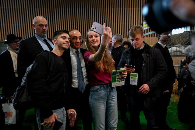 French far-right Reconquete party leader Eric Zemmour (C) poses with visitors as he visits the Paris International Agricultural Show (Salon de l'Agriculture) at Paris Expo Porte de Versailles in Paris on February 26, 2026. (Photo by Anna KURTH / AFP)