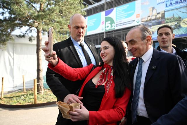 French far-right Reconquete party leader Eric Zemmour (R) poses with a visitor as he visits the Paris International Agricultural Show (Salon de l'Agriculture) at Paris Expo Porte de Versailles in Paris on February 26, 2026. (Photo by Anna KURTH / AFP)