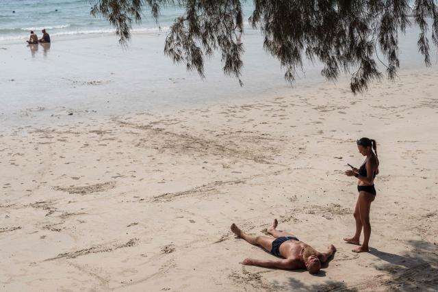 A tourist lays on the sand at Nang Ram Beach in Pattaya on February 26, 2026. (Photo by Chanakarn LAOSARAKHAM / AFP)