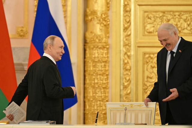 Russia's President Vladimir Putin (L) and Belarus' President Alexander Lukashenko (R) arrive to attend a meeting of the Supreme State Council of the Union State of Russia and Belarus in Moscow on February 26, 2026. (Photo by HECTOR RETAMAL / POOL / AFP)
