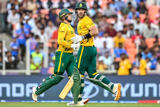 South Africa's captain Aiden Markram (R) and his teammate Ryan Rickelton run between the wickets during the 2026 ICC Men's T20 Cricket World Cup Super Eights match between West Indies and South Africa at Narendra Modi Stadium in Ahmedabad on February 26, 2026. (Photo by Shammi MEHRA / AFP)