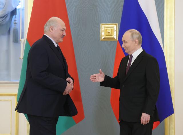 Russia's President Vladimir Putin (R) greets Belarus' President Alexander Lukashenko (L) prior to a meeting of the Supreme State Council of the Union State of Russia and Belarus in Moscow on February 26, 2026. (Photo by Maxim SHIPENKOV / POOL / AFP)