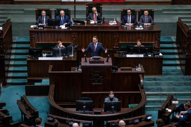 Poland's Minister of Foreign Afairs Radoslaw Sikorski (C) presents the main points of the Polish government's foreign policy during a session at the Polish Parliament in Warsaw on February 26, 2026. (Photo by Wojtek RADWANSKI / AFP)