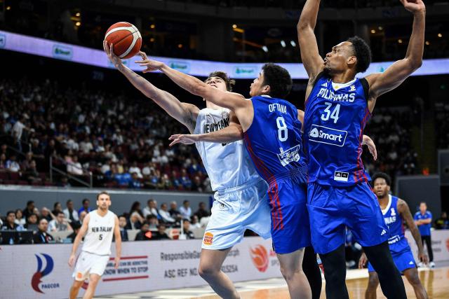 Taine Murray (L) of New Zealand lays up against Calvin Oftana (C) and AJ Edu of the Philippines during the 2027 FIBA Basketball World Cup Asian qualifier first round group A match between New Zealand and the Philippines at the Mall of Asia Arena in Pasay City, Metro Manila on February 26, 2026. (Photo by Ted ALJIBE / AFP)