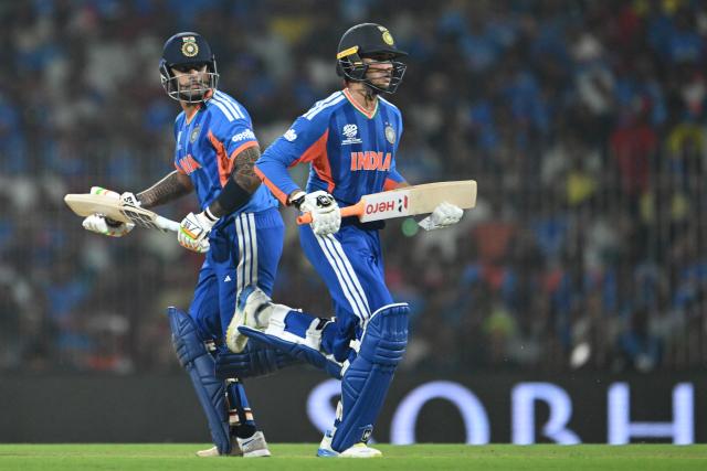 India's Abhishek Sharma (R) and captain Suryakumar Yadav run between the wickets during the 2026 ICC Men's T20 Cricket World Cup Super Eights match between India and Zimbabwe at the MA Chidambaram Stadium in Chennai on February 26, 2026. (Photo by R. Satish BABU / AFP)