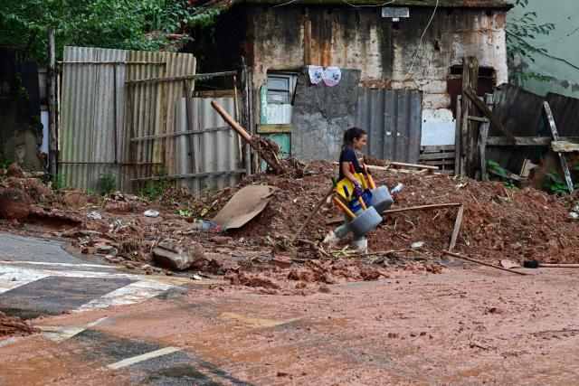 A resident removes belongings after flooding and landslides in the Los Tres Molinos neighborhood in Juiz de Fora, Minas Gerais state, Brazil, on February 26, 2026. Despair hung over two cities in southeastern Brazil on February 25 as rescuers and residents searched for 21 people missing after torrential rains unleashed flooding and landslides that killed at least 46. (Photo by Pablo PORCIUNCULA / AFP)
