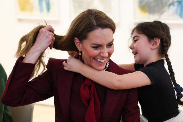 Britain's Catherine, Princess of Wales, smiles as she receives a necklace made by a child at an art workshop during a visit to Oriel Davies, a public contemporary art gallery in Newtown, rural Powys, central Wales on February 26, 2026. (Photo by Phil Noble / POOL / AFP)