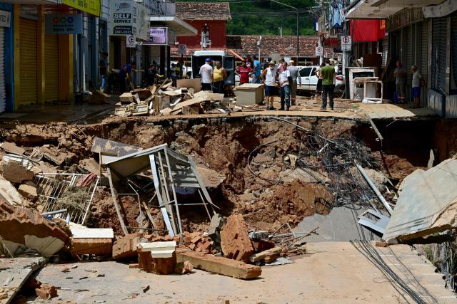 TOPSHOT - View of destruction in the commercial district of Uba, in Minas Gerais State, Brazil, on February 25, 2026, after the Uba River overflowed due to heavy rains. Despair hung over two cities in southeastern Brazil on February 25 as rescuers and residents searched for 27 people missing after torrential rains unleashed flooding and landslides that killed at least 40. (Photo by Pablo PORCIUNCULA / AFP)
