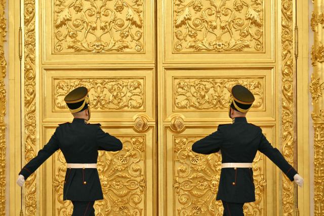 Russian honor guard soldiers approach to open the doors as Russian and Belarusian presidents arrive to attend a meeting of the Supreme State Council of the Union State of Russia and Belarus in Moscow on February 26, 2026. (Photo by HECTOR RETAMAL / AFP)