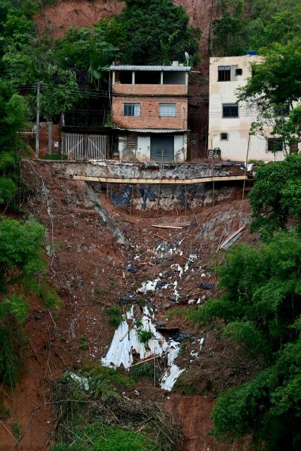 View of a landslide after heavy rainfall in the Tres Moinhos neighborhood in Juiz de Fora, Minas Gerais state, Brazil, on February 26, 2026. Despair hung over two cities in southeastern Brazil on February 25 as rescuers and residents searched for 21 people missing after torrential rains unleashed flooding and landslides that killed at least 46. (Photo by Pablo PORCIUNCULA / AFP)