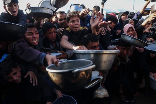 Palestinians react as they wait to receive food at a soup kitchen in Khan Yunis, in the southern Gaza Strip on February 26, 2026. Despite a US-brokered ceasefire that entered its second phase last month, shortages remain in Gaza, whose battered economy and material damage have rendered most residents at least partly dependent on humanitarian aid for their basic needs. (Photo by BASHAR TALEB / AFP)