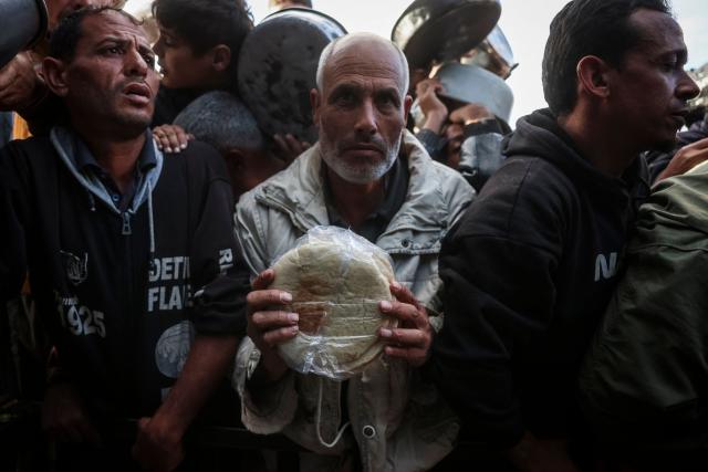 A Palestinian man reacts while waiting to receive food at a soup kitchen in Khan Yunis, in the southern Gaza Strip on February 26, 2026. Despite a US-brokered ceasefire that entered its second phase last month, shortages remain in Gaza, whose battered economy and material damage have rendered most residents at least partly dependent on humanitarian aid for their basic needs. (Photo by BASHAR TALEB / AFP)