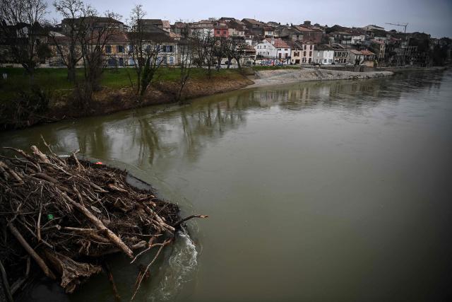This photograph shows tree trunks stuck by a bridge days after Storm Nils hit the area along the River Garonne at Tonneins, south-western France on February 26, 2026. The record streak of consecutive rainy days in France ended on February 23, at 40 days, but the flooding is still not over despite signs of improvement, according to Météo-France. A new record was also set for the length of time France has been under red flood alert, Vigicrues reported on February 24, with 14 days. In the West, water levels continued to slowly recede, suggesting a gradual return to normal for some affected areas. (Photo by Christophe ARCHAMBAULT / AFP)