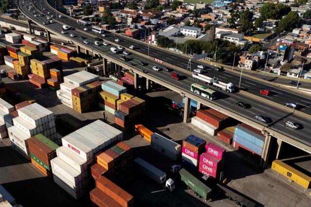This aerial view shows Dr. Ricardo Balbin highway and containers at Dock Sud Port in Avellaneda, Buenos Aires province, Argentina, on February 26, 2026. (Photo by LUIS ROBAYO / AFP)