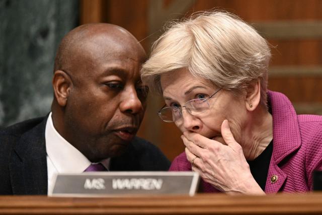 (L/R) Committee chairman US Senator Tim Scott, Republican from South Carolina, speaks with Senator Elizabeth Warren, Democrat from Massachusetts, speak with each other during a Senate Committee on Banking, Housing, and Urban Affairs hearing titled "Update from the Prudential Regulators: Rightsizing Regulation to Promote American Opportunity," on Capitol Hill in Washington, DC on February 26, 2026. (Photo by Brendan SMIALOWSKI / AFP)