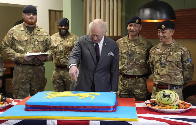 Britain's King Charles III cuts a cake during a visit to the 7th Air Defence Group Royal Artillery at Baker Barracks in Emsworth, southern England on February 26, 2026. (Photo by Andrew Matthews / POOL / AFP)