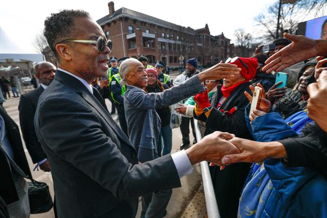 Jessie Jackson Kr. (L) and Rev. Al Sharpton (C) greet people waiting in line to enter the Rainbow PUSH Coalition headquarters as US civil rights leader Jesse Jackson lies in repose inside the building in Chicago, Illinois, on February 26, 2026. Veteran US civil rights activist Reverend Jesse Jackson, one of the nation's most influential Black voices, died earlier this month at the age of 84. Jackson, a Baptist minister, had been a civil rights leader since the 1960s, when he marched with Martin Luther King Jr. and helped fundraise for the cause. (Photo by KAMIL KRZACZYNSKI / AFP)