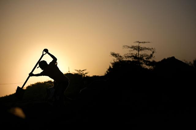 A worker shovels sand on the banks of the Apure River in San Fernando de Apure, Apure State, Venezuela, on February 26, 2026. (Photo by Federico PARRA / AFP)
