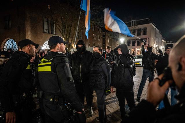 Attendees face police as they take part in a gathering by Defend Netherlands in tribute to French far-right activist Quentin Deranque, who died after being attacked on the sidelines of a far-right protest against a La France Insoumise (LFI) event, at the ACU political and cultural centre in Utrecht on February 26, 2026. Deranque, 23, died from head injuries following clashes between radical-left and far-right supporters on the sidelines of a February 12 protest against a politician from the left-wing LFI party in Lyon. (Photo by Josh Walet / ANP / AFP) / Netherlands OUT