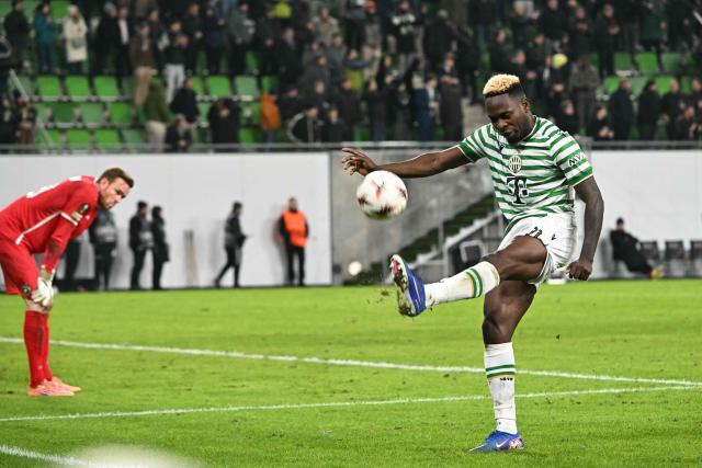 TOPSHOT - Ferencvaros' Nigerian forward #11 Bamidele Yusuf (R) throws a celebratory kick to the ball as Ludogorets Razgrad's German goalkeeper #39 Hendrik Bonmann (L) reacts after winning the UEFA Europa League knockout round playoff second leg football match Ferencvaros v Ludogorets Razgrad in Budapest, Hungary, on February 26, 2026. (Photo by Attila KISBENEDEK / AFP)