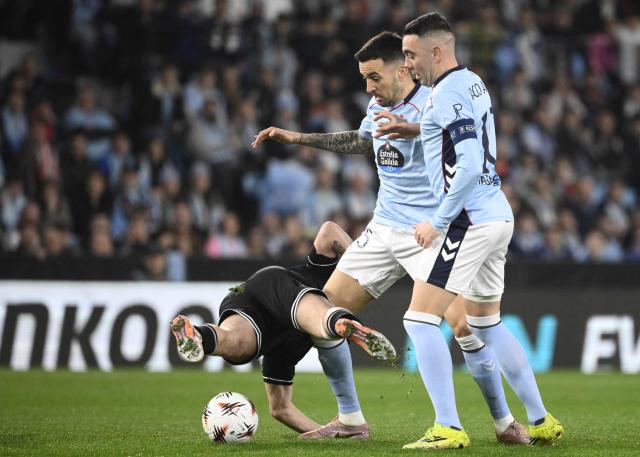 PAOK's Greek midfielder #20 Christos Zafeiris (down) fights for the ball with Celta Vigo's Spanish forward #15 Matias Vecino (C) and Celta Vigo's Spanish forward #10 Iago Aspas during the UEFA Europa League knockout round play-off second leg football match between RC Celta de Vigo and PAOK FC at Balaidos Stadium in Vigo on february 26, 2026. (Photo by Miguel RIOPA / AFP)