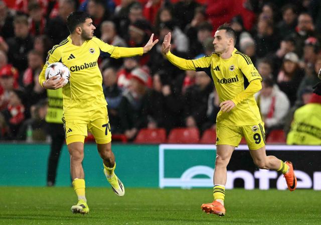 Fenerbahce's Turkish striker #09 Muhammed Kerem Akturkoglu (R) celebrates scoring the team's second goal with Fenerbahce's Turkish midfielder #70 Oguz Aydin during the UEFA Europa League Knockout Round Play-off second-leg football match between Nottingham Forest and Fenerbahce SK at The City Ground in Nottingham, central England, on February 26, 2026. (Photo by Oli SCARFF / AFP)