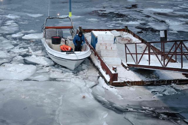 A fisherman docks a boat amid frozen waters at a harbour in Nuuk, Greenland, on February 26, 2026. Greenland’s economy is primarily focused on fishing, but with the United States’ growing interest in the country, its prospects appear to be diversifying. However, specialists warn that this could lead to economic imbalance for the Arctic island. (Photo by Florent VERGNES / AFP)