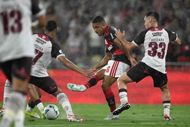 Flamengo's forward #16 Samuel Lino (C) kicks the ball past Lanus' midfielder #17 Agustin Medina (L) and defender #33 Tomas Guidara (R) during the Recopa Sudamericana second leg final football match between Brazil's Flamengo and Argentina's Lanus at the Maracana Stadium in Rio de Janeiro, Brazil, on February 26, 2026. (Photo by MAURO PIMENTEL / AFP)