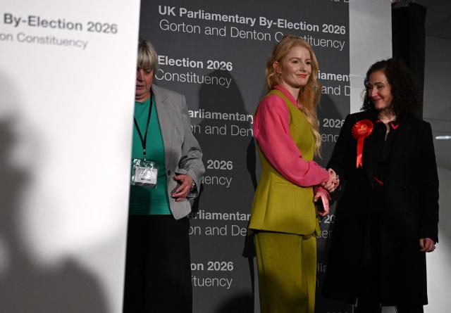 Green Party candidate Hannah Spencer is congratulated by Labour party candidate Angeliki Stogia after being announced as the winner of the Gorton and Denton Parliamentary by-election, at Manchester Central Convention Complex in Manchester, northern England on February 27, 2026. (Photo by Paul ELLIS / AFP)
