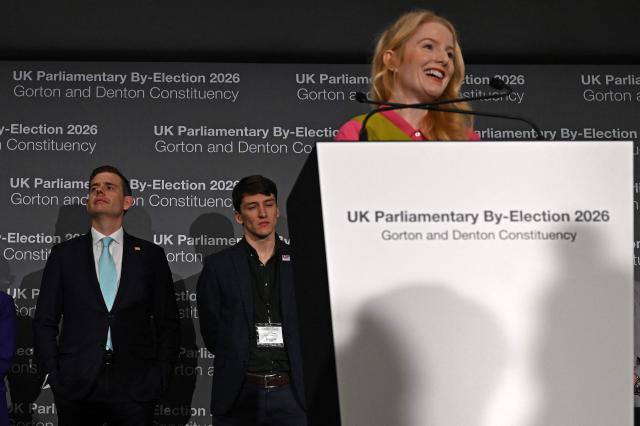 Reform UK candidate Matt Goodwin (L) listens as Green Party candidate Hannah Spencer gives her acceptance speech after winning the Gorton and Denton Parliamentary by-election, at Manchester Central Convention Complex in Manchester, northern England on February 27, 2026. (Photo by Paul ELLIS / AFP)