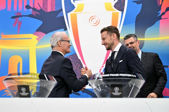 UEFA Foundation for Children ambassador and former Sevilla midfielder, Ivan Rakitic (C) shakes hands with UEFA Deputy General Secretary Giorgio Marchetti (L) ahead of the 2025-2026 UEFA Champions League round of 16, quarter-final and semi-final draw at the House of European Football in Nyon, western Switzerland on February 27, 2026. (Photo by Harold CUNNINGHAM / AFP)