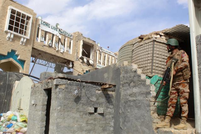 A Pakistani soldier stands guard at the Pakistan-Afghanistan border in Chaman on February 27, 2026, following overnight cross-border firing between the two countries. Pakistan bombed major cities in Afghanistan including the capital Kabul on February 27, with Islamabad's defence minister declaring the neighbours at "open war" following months of tit-for-tat clashes. Pakistan's latest operation came after Afghan forces attacked Pakistani border troops on February 26 night in retaliation for earlier air strikes by Islamabad. (Photo by Abdul BASIT / AFP)
